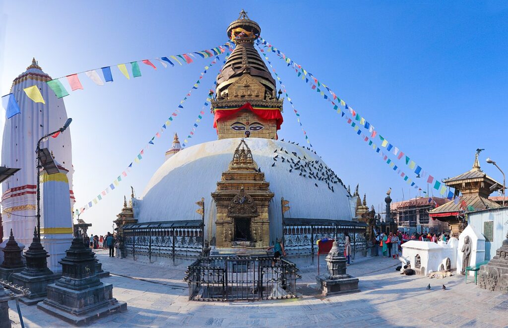 Perched gracefully on a hilltop west of Kathmandu, Swayambhunath—popularly known as the Monkey Temple—is one of Nepal’s most enduring symbols of spirituality and culture. With its striking white dome, golden spire, and the ever-watchful eyes of Buddha, the stupa has inspired pilgrims, monks, travelers, and storytellers for centuries. Perched gracefully on a hilltop west of Kathmandu, Swayambhunath—popularly known as the Monkey Temple—is one of Nepal’s most enduring symbols of spirituality and culture. With its striking white dome, golden spire, and the ever-watchful eyes of Buddha, the stupa has inspired pilgrims, monks, travelers, and storytellers for centuries. For first-time visitors, Swayambhunath offers much more than just a temple tour. It is a place where history, art, religion, and breathtaking views of the valley come together. In this ultimate guide, we will uncover its fascinating history, unique architecture, surrounding shrines, festivals, opening hours, entry fees, travel tips, and how you can make the most of your visit.